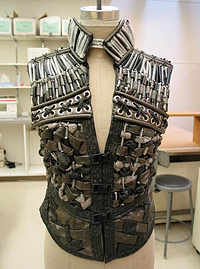 Photo of an "armored" costume worn by the character of Macduff featuring intricate beading and fabric.