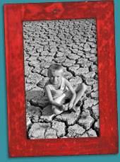 Framed photo of young boy sitting on dry, cracked ground.